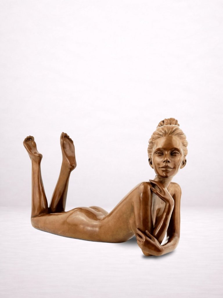 Sculpture en bronze d’une femme allongée sur le ventre, jambes relevées, vue de profil droit.