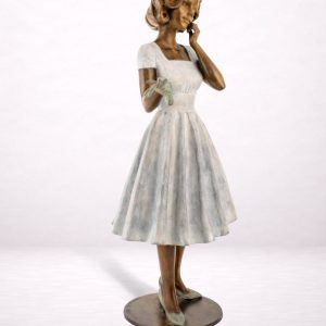 Sculpture en bronze d’une femme en robe fluide, vue trois-quarts avant.