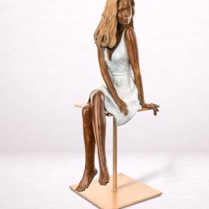 Sculpture en bronze d’une femme assise en hauteur, vue avant.