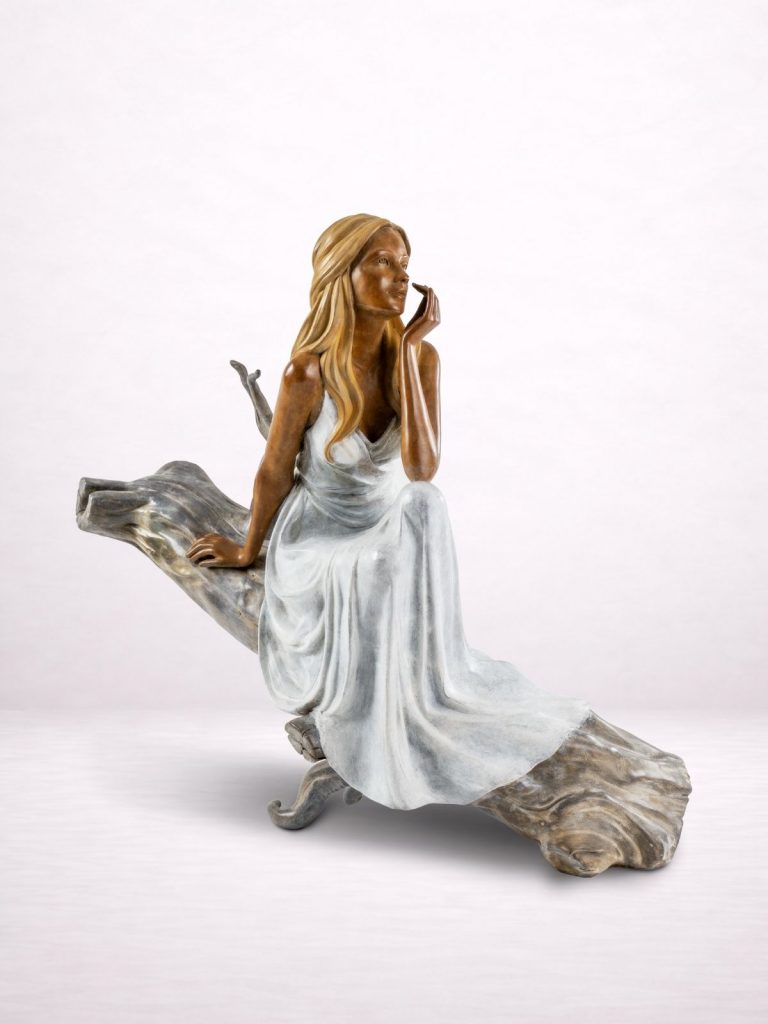 Sculpture en bronze d’une femme assise sur un tronc, vue avant.
