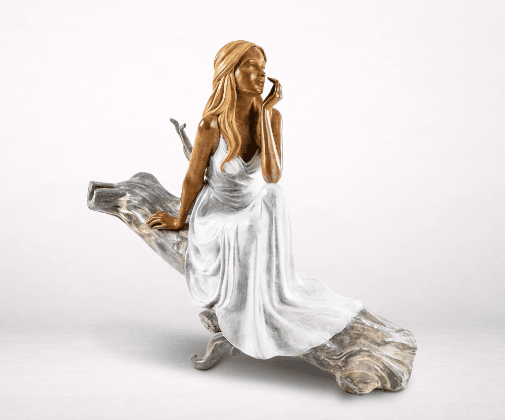 Sculpture en bronze d'une femme en robe assise sur une branche de bois flotté