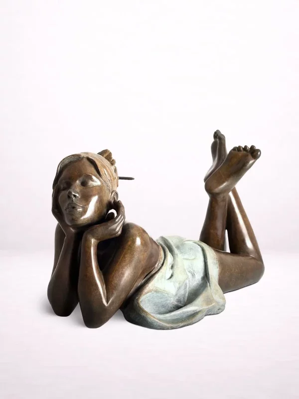 Sculpture en bronze d’une femme drapée allongée vue de face