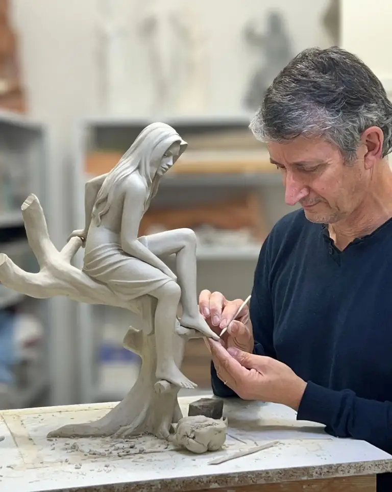 Alain Choisnet sculptant une œuvre en argile dans son atelier.
