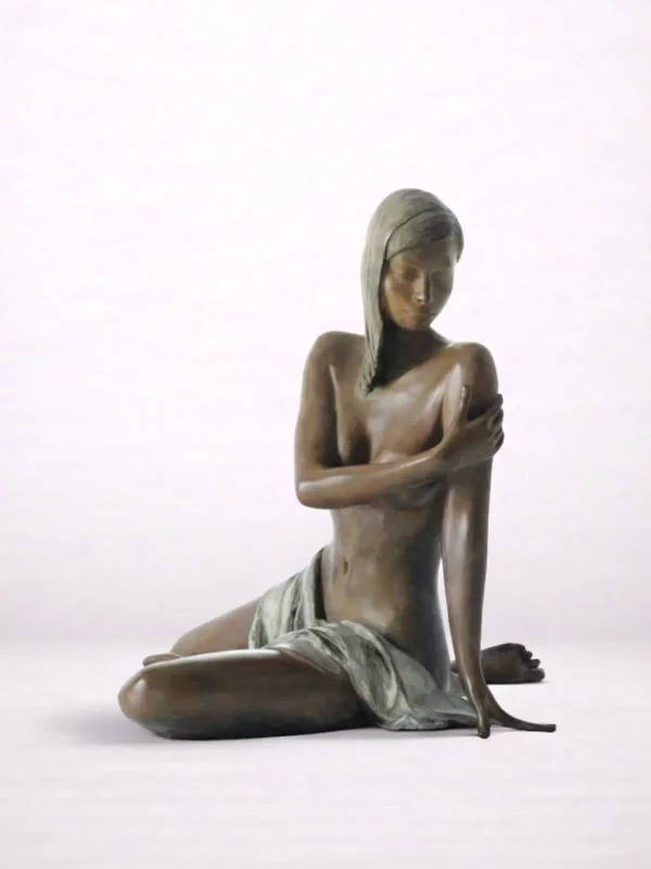 Sculpture en bronze d’une femme drapée assise par terre et regardant vers le sol.