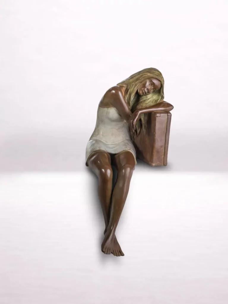 Sculpture en bronze d’une femme assise appuyée sur une valise, vue de face.