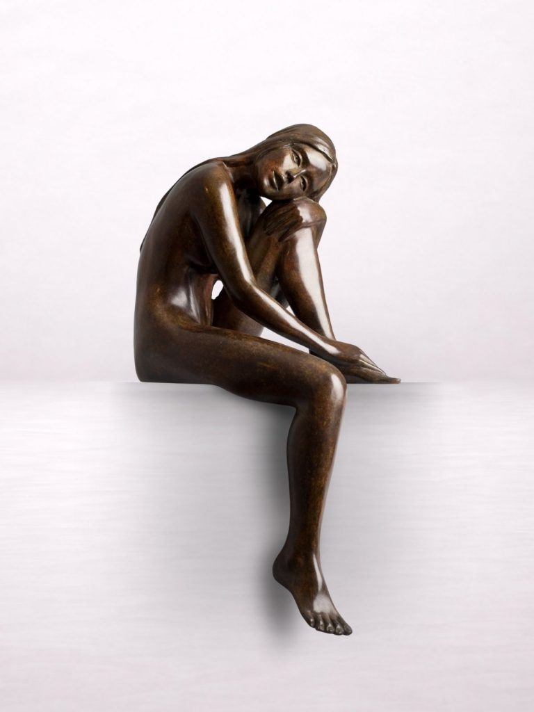 Sculpture en bronze d’une femme nue assise reposant sa tête sur son genou.