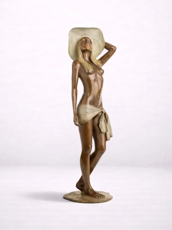 Sculpture en bronze d’une femme debout en paréo et large chapeau regardant vers le ciel.