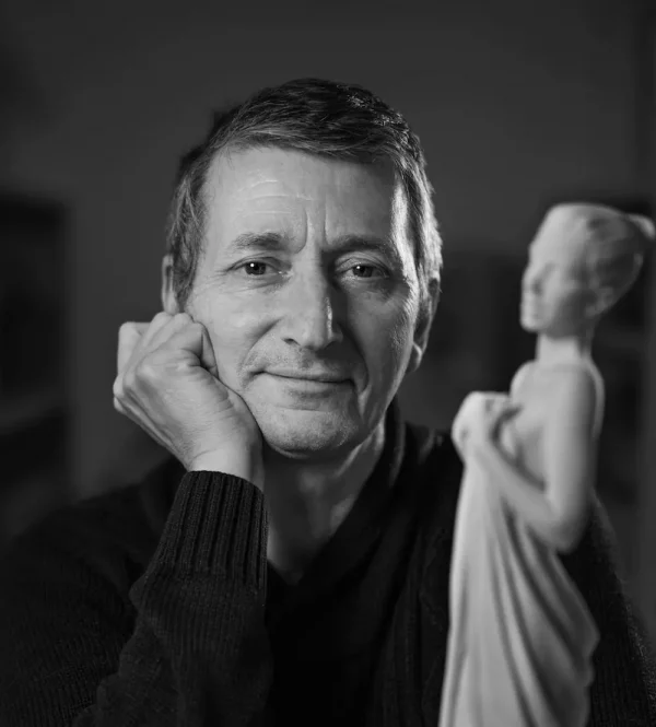 Portrait d’Alain Choisnet tenant l’une de ses sculptures.