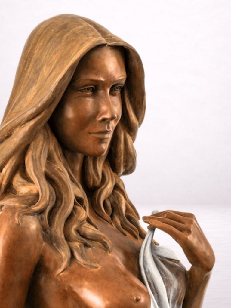 Sculpture en bronze d’une femme, détail du visage et du drapé.