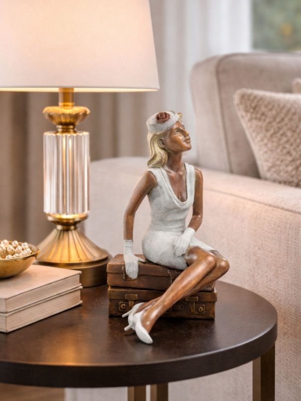 sculpture bronze femme assise sur valises en situation intérieur lampe salon lorette