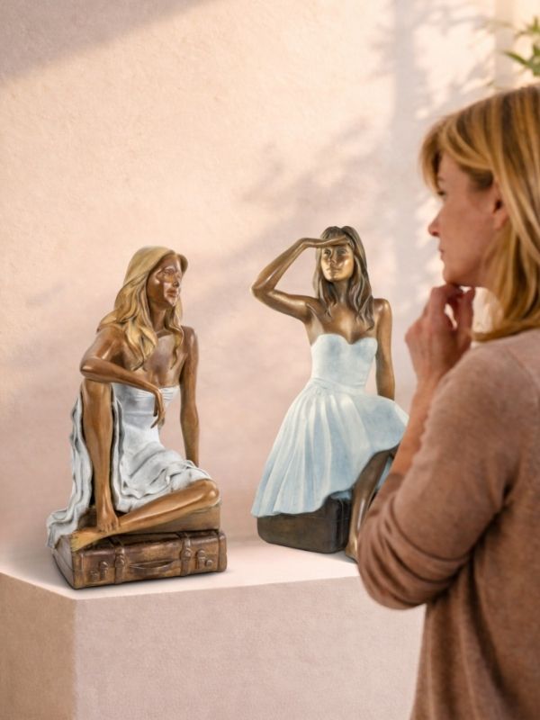 Femme observant deux sculptures en bronze dans une galerie, moment d’hésitation avant achat