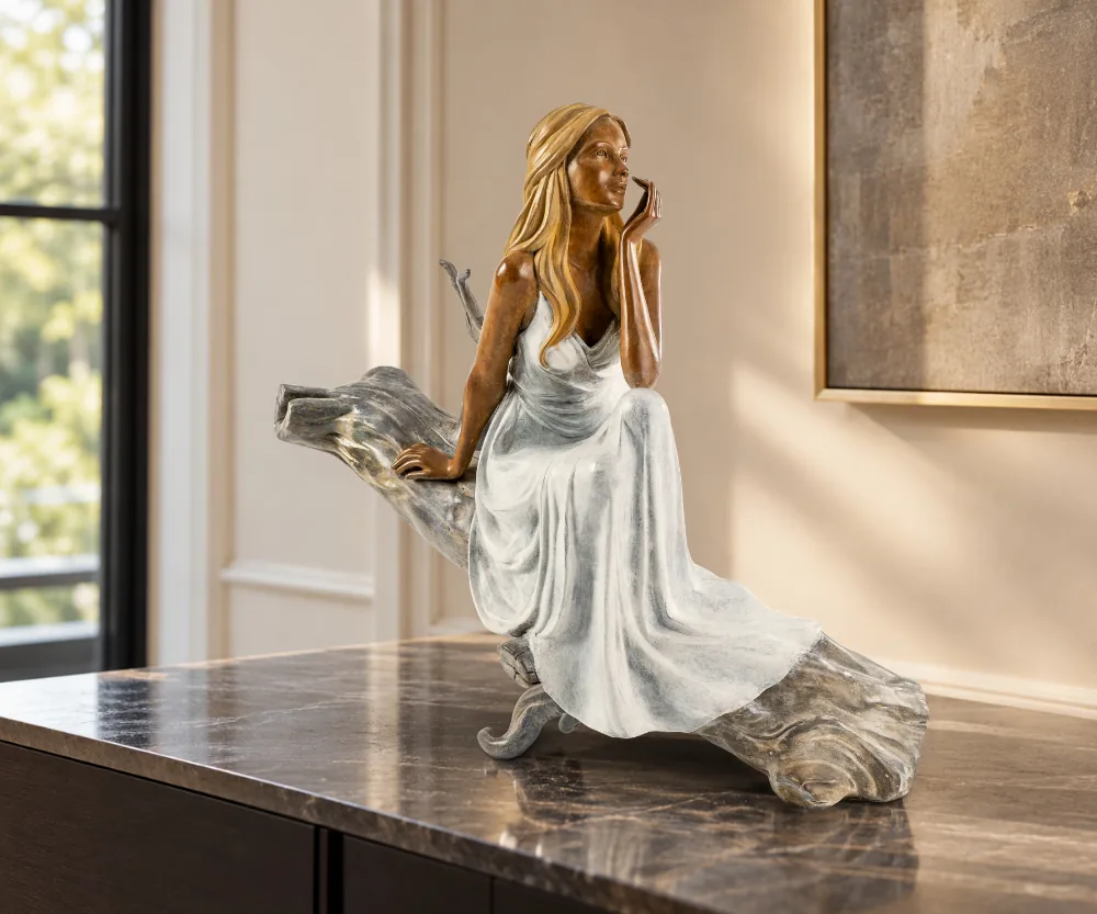 Sculpture en bronze contemporain Lilas, assise dans une attitude paisible, sur un meuble dans un intérieur raffiné.